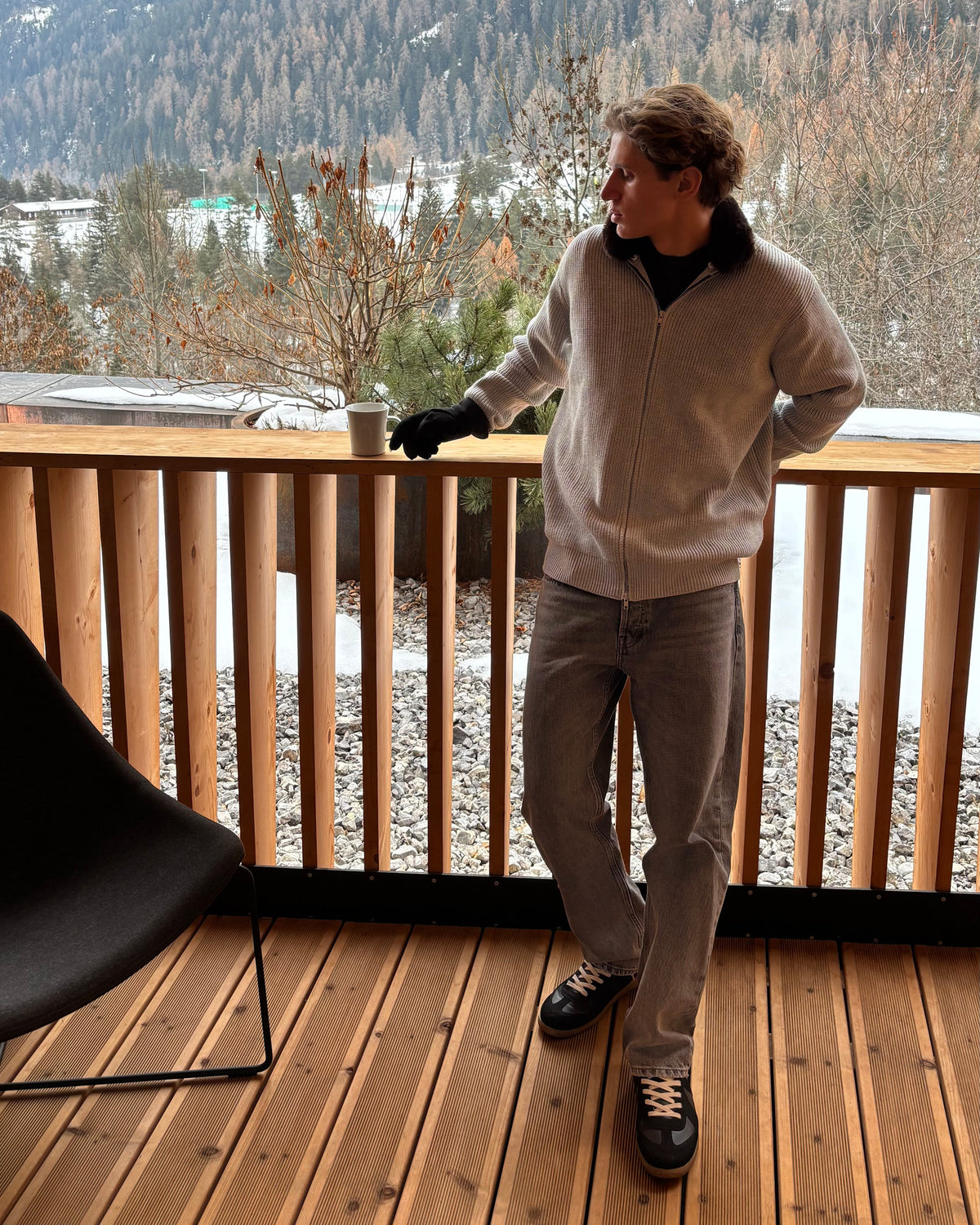 The Engadin Zip Knit with faux fur collar, worn on a mountain terrace